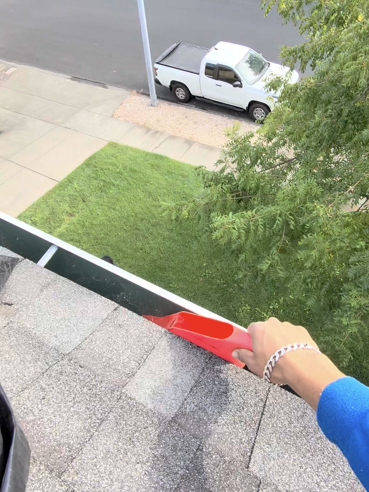CAMTERRA technician clearing a roof gutter with a scoop